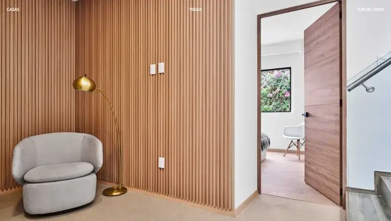 Rincón de estar de Tekax con sillón, lámpara y muro de listones de madera
